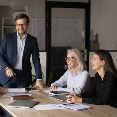 Three professionals at a table with a fourth person partly out of frame