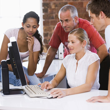 Stakeholders and partners of Oakford Group Limited sharing ideas and reviewing property operations on a screen.